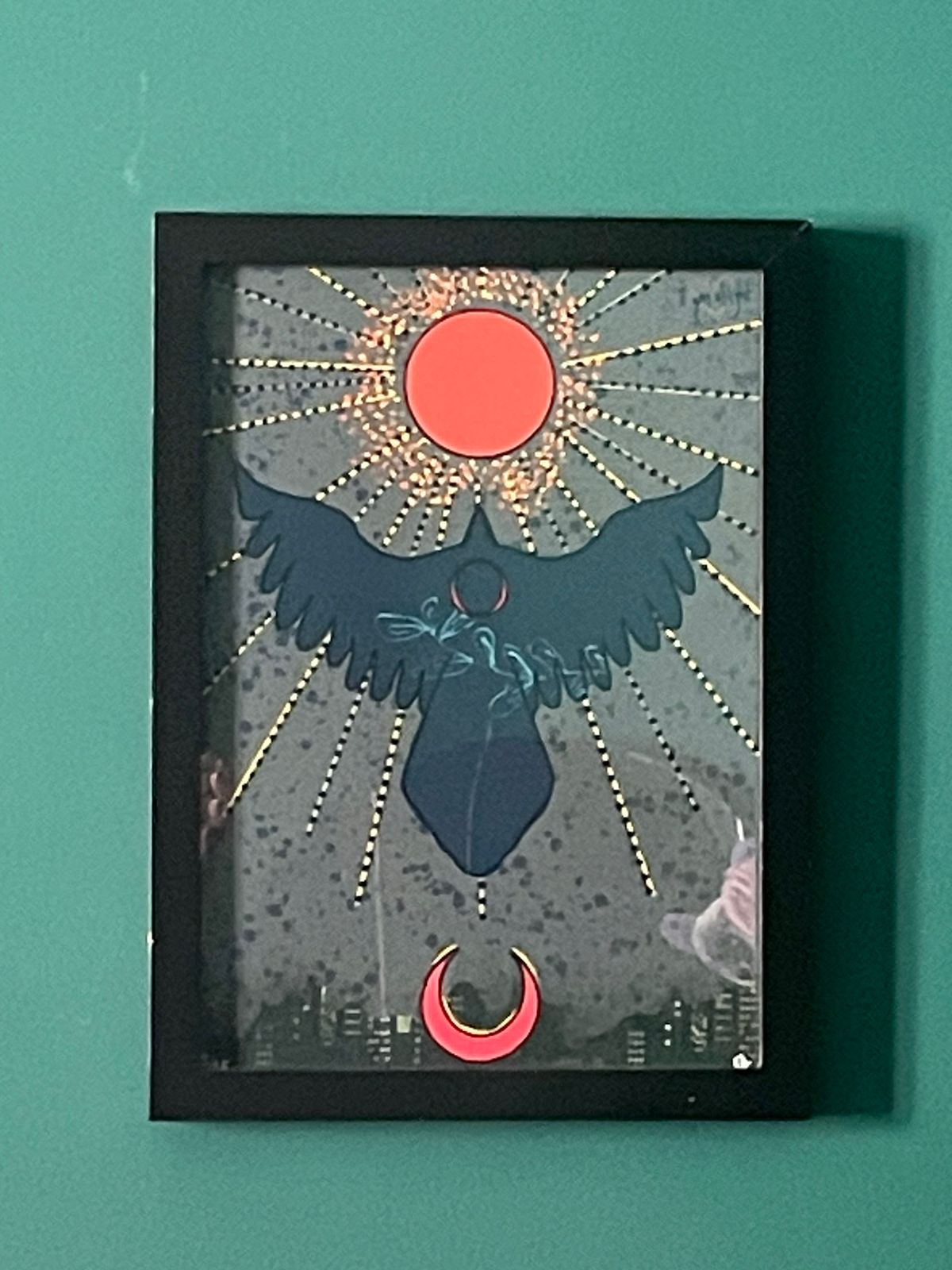 Framed artwork with a silhouette of a bird, red circle, and crescent moon on a teal background